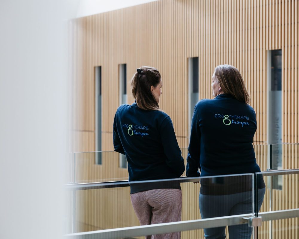 Twee ergotherapeuten van Ergotherapie Krimpen lopen samen door het gezondheidscentrum